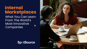 Two business people meet at a table with a laptop and papers